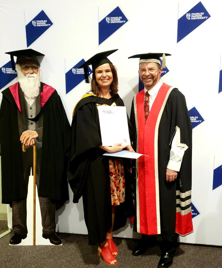 Student holding graduation certificate and standing next to the CDU Vice Chancellor