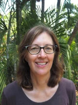 Maxine Piggott head and shoulders, with green leafy background