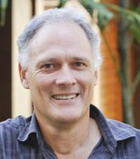 Allan Dale, head and shoulders, with out of focus plant in background