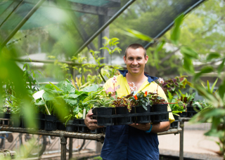 Student holding a tray of plants